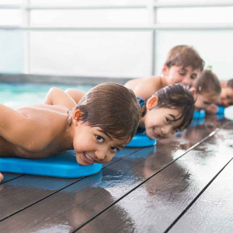 group of kids half climbing out of the pool